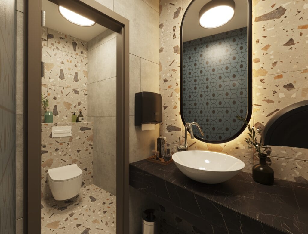 Men’s restroom with terrazzo wall tiles, oval mirror, and suspended toilet