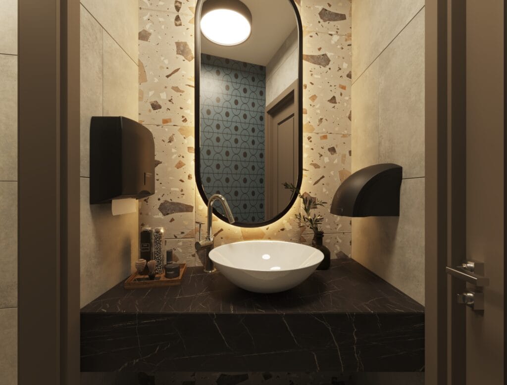 Modern men’s restroom with terrazzo tiles, oval mirror, and round sink basin