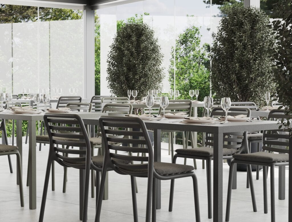 Outdoor terrace dining with black chairs and glass surroundings - Intervibe Studio