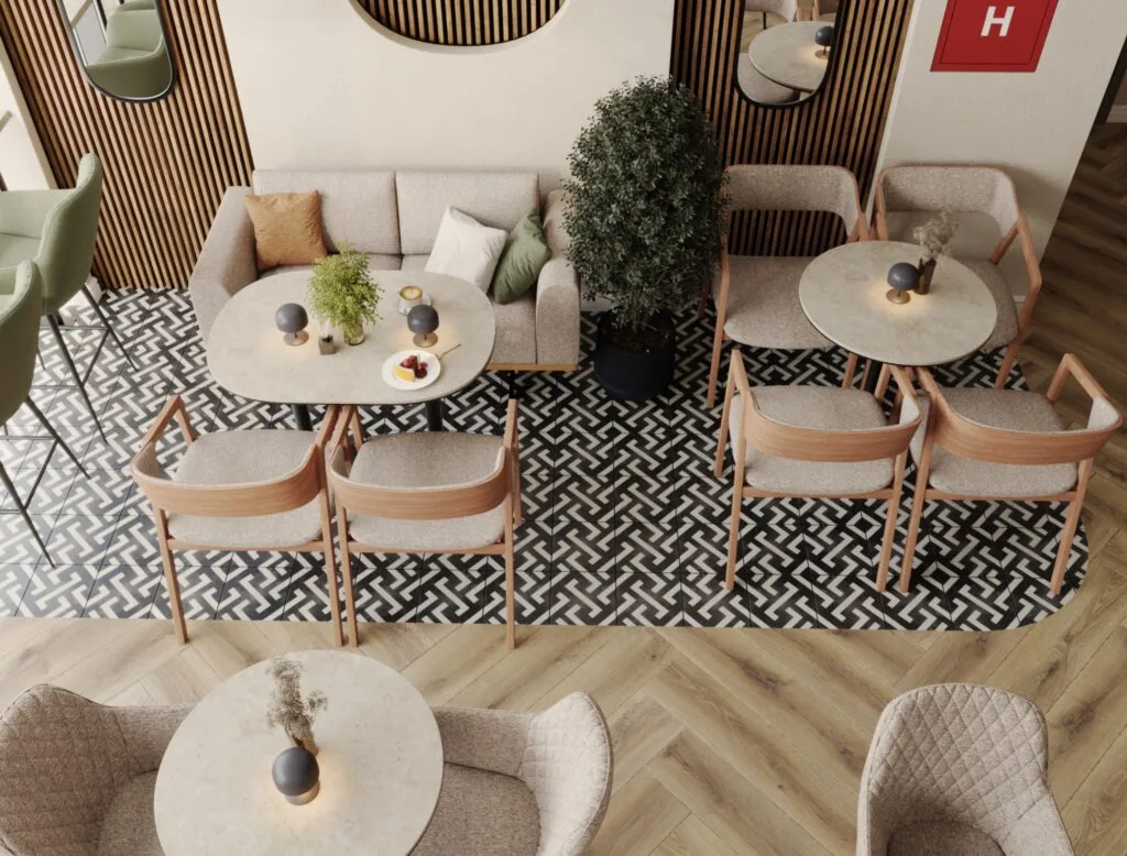 Top view of café seating with sofas, round tables, and patterned floor tiles