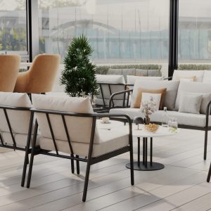 Glass-enclosed café terrace with beige lounge chairs, black frame seating, and modern tables