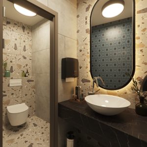 Men’s restroom with terrazzo wall tiles, oval mirror, and suspended toilet