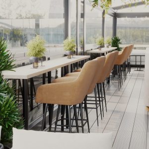 Outdoor café terrace with high bar table, mustard-colored bar stools, and greenery